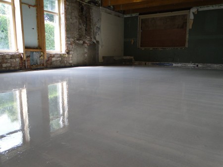 De gietvloer over de vloerverwarming